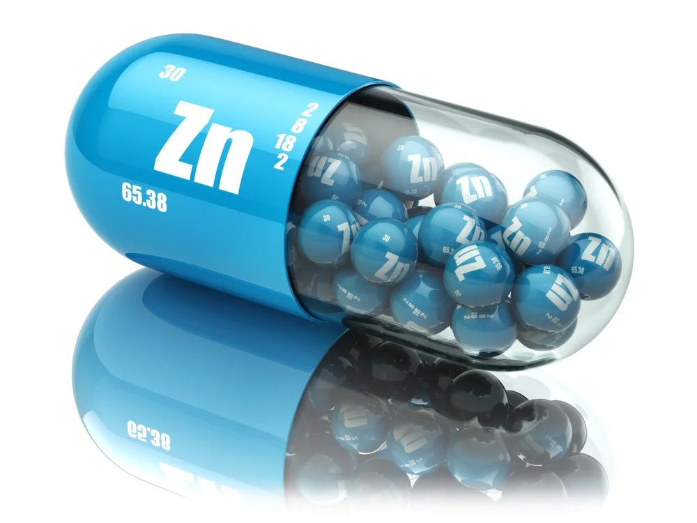 Zinc acné : Le supplément naturel contre les boutons Zinc acné : Le supplément en gélules posé sur une surface blanche avec des comprimés épars