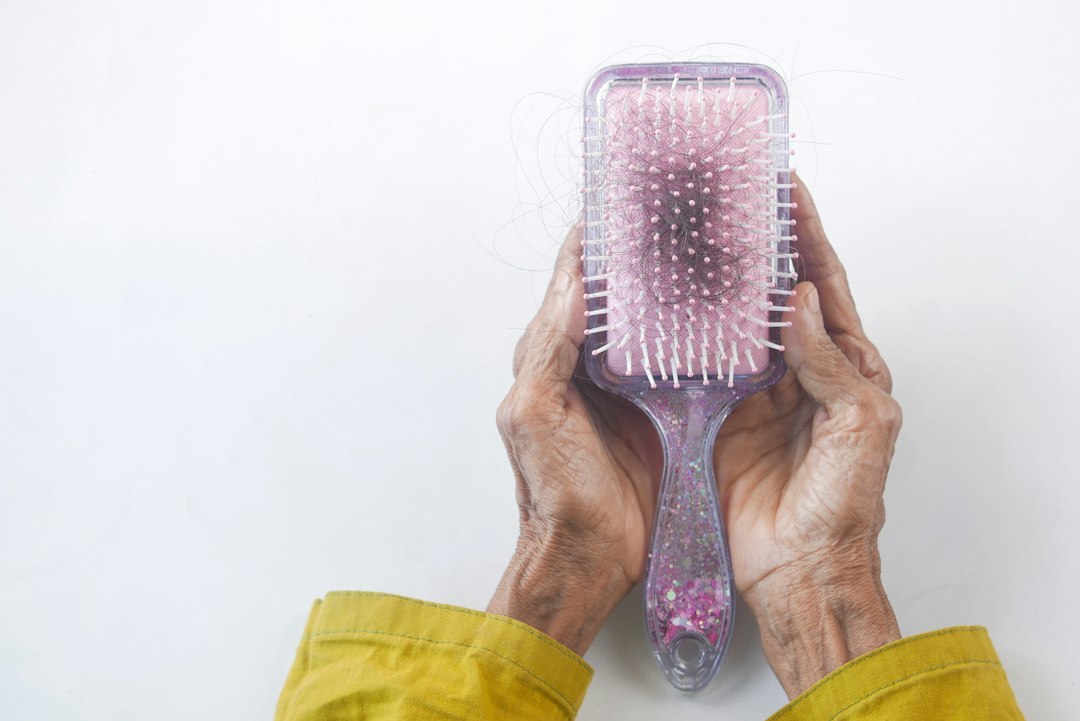 Personne tenant une brosse à cheveux pour un brossage doux du cuir chevelu