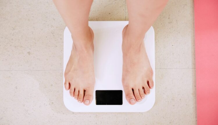 Perte de poids : femme qui se pèse sur une balance pour suivre ses progrès