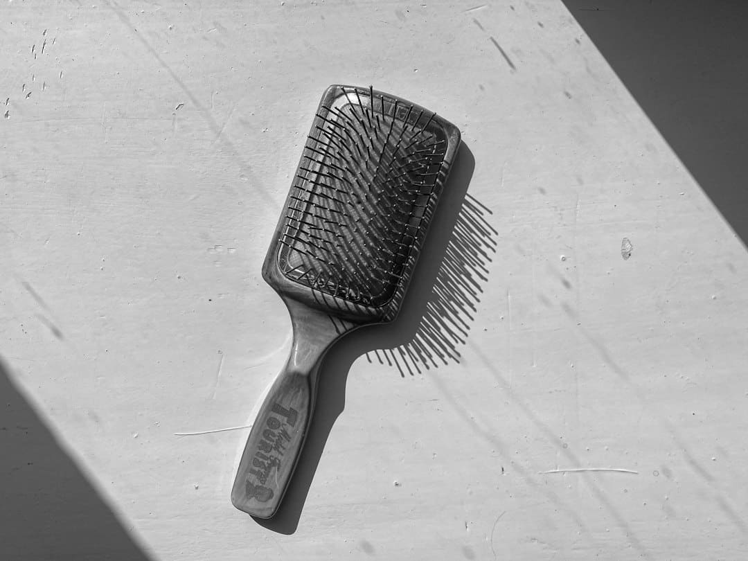 Alopécie Femme : 4 Erreurs Choquantes à Éviter Absolument chute de cheveux visible sur une brosse, signe fréquent d'alopécie chez la femme