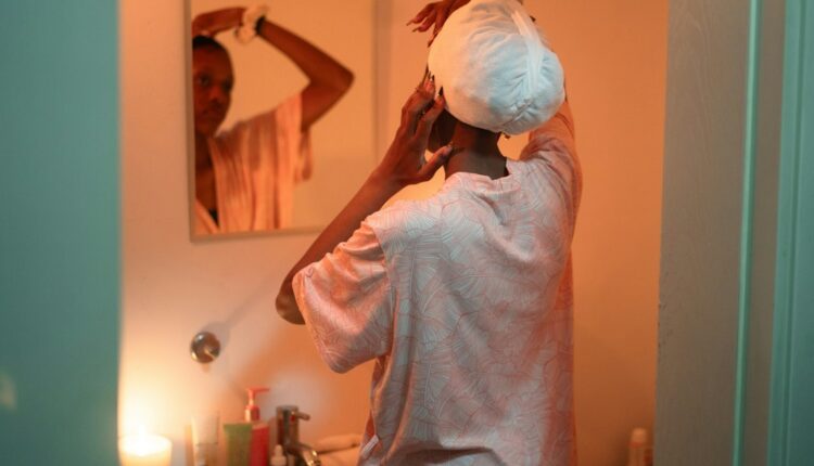 Femme utilisant un shampoing cheveux gras dans la salle de bain
